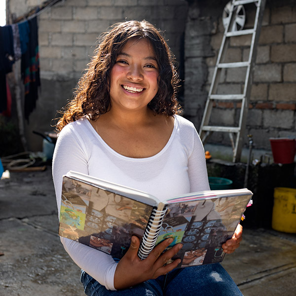 Abigail uit Mexico zit buiten met haar studieboek.