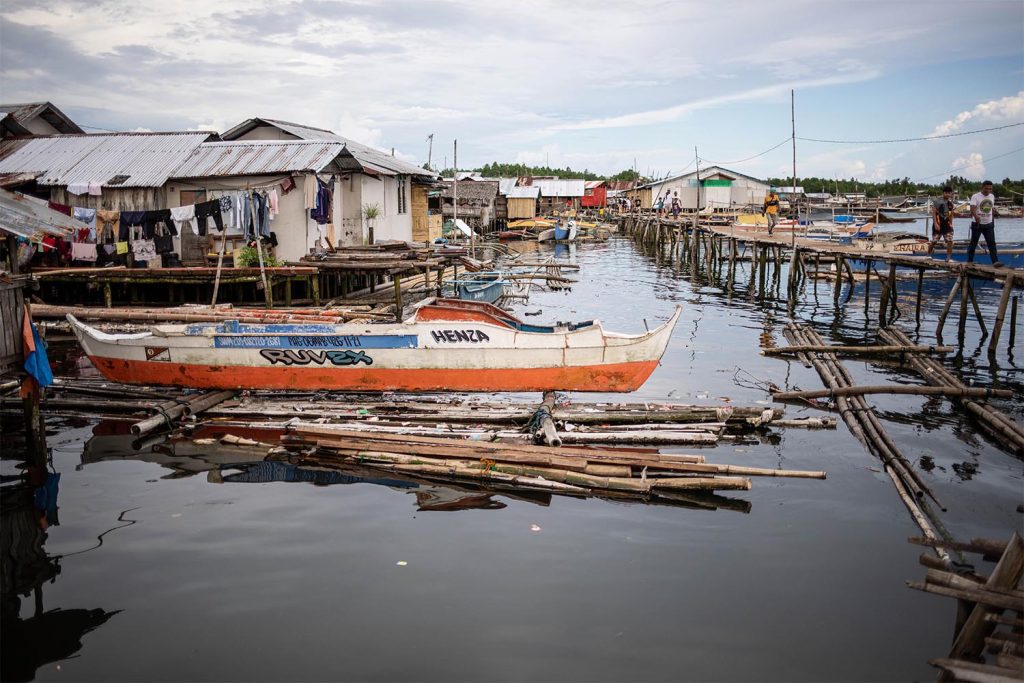 Foto van huizen, boten en steigers aan het water in de Filipijnen