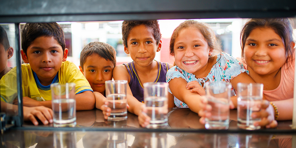 kinderen in Peru met een glas water in hun hand