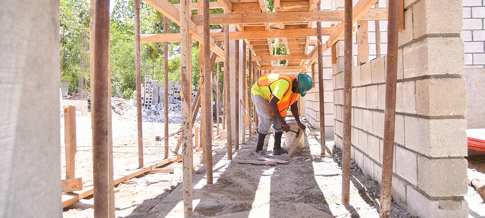 Een man werkt aan de wederopbouw van een kerkgebouw in Haïti. 