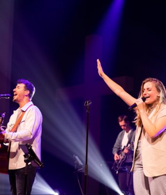 Artiesten Sander & Angela zingen en spelen hun muziek op een podium.